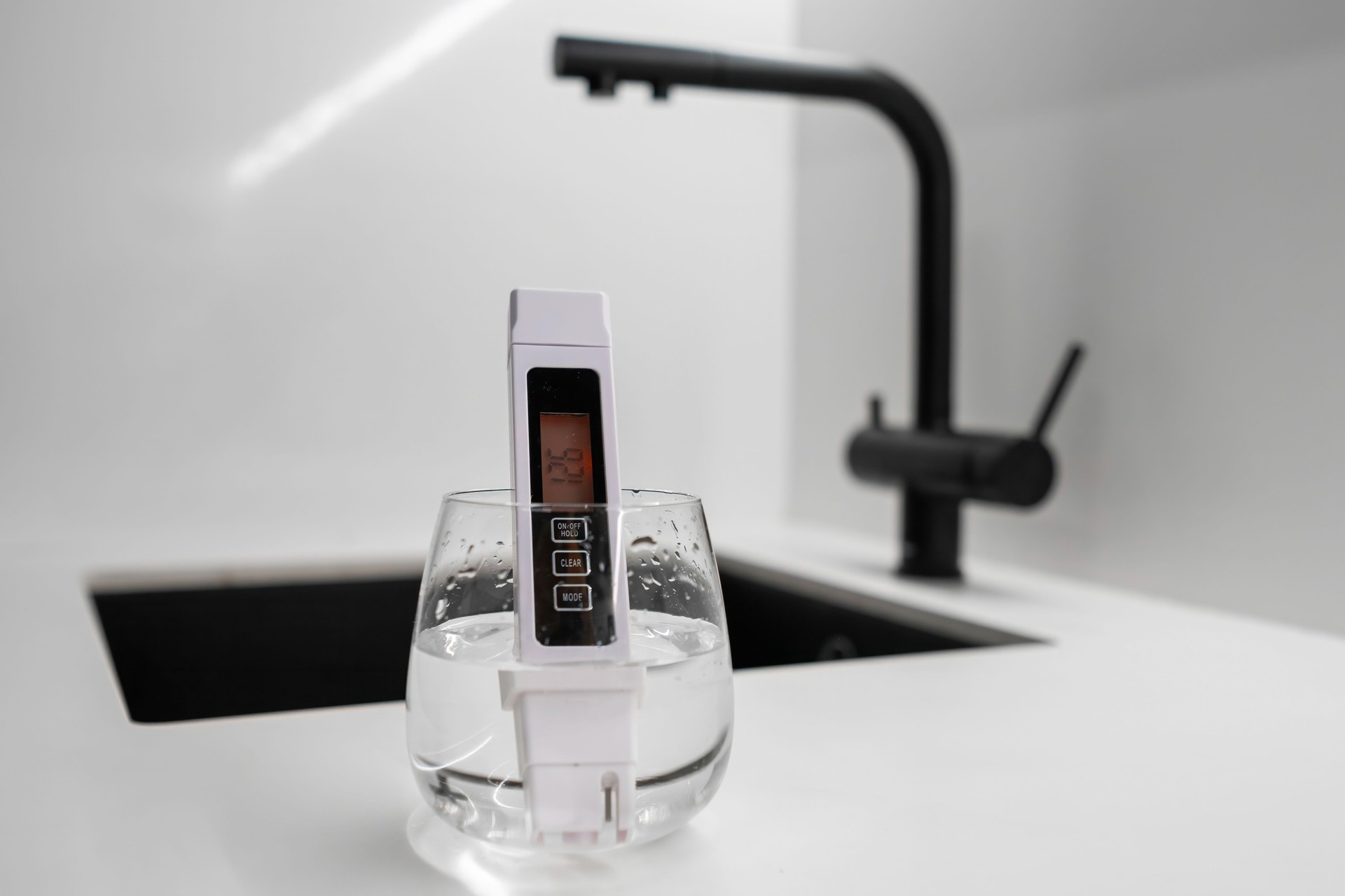 Conductometer or TDS water quality meter is immersed in a beaker of water to check purity